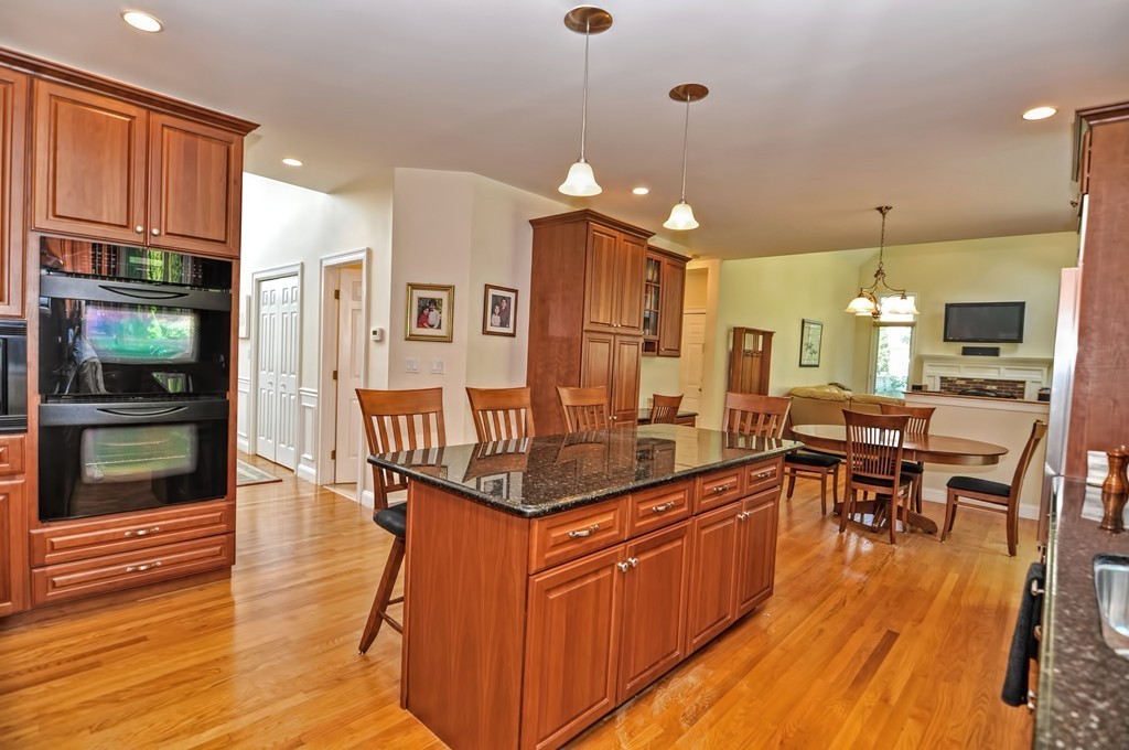 316 Hartman Road Newton, MA 02459 - Photo 8 of 30 a kitchen with stainless steel appliances granite countertop a stove top oven a refrigerator a dining table and chairs with wooden floor