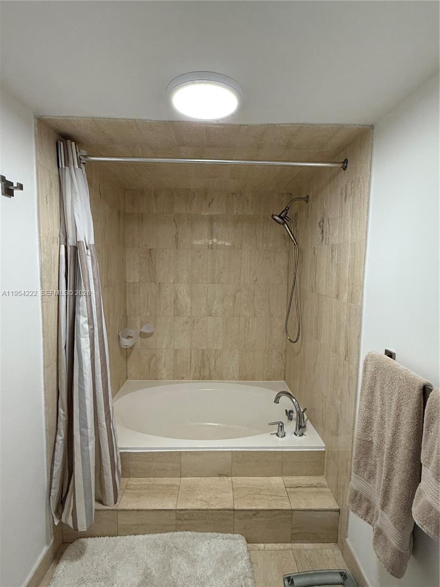 201 Crandon Boulevard, Unit 928 Key Biscayne, FL 33149 - Photo 15 of 38 a bathroom with a tub and a shower