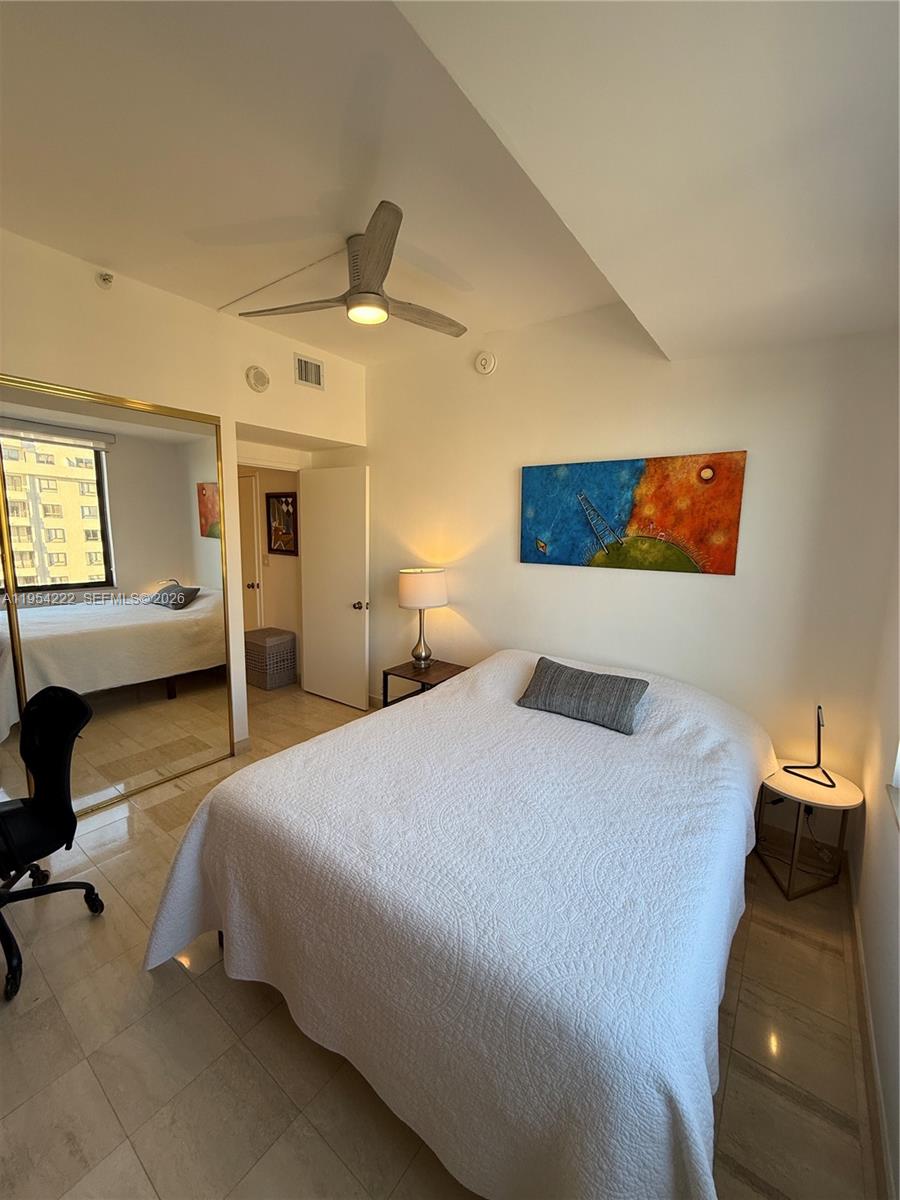 201 Crandon Boulevard, Unit 928 Key Biscayne, FL 33149 - Photo 17 of 38 a bedroom with a bed and ceiling fan