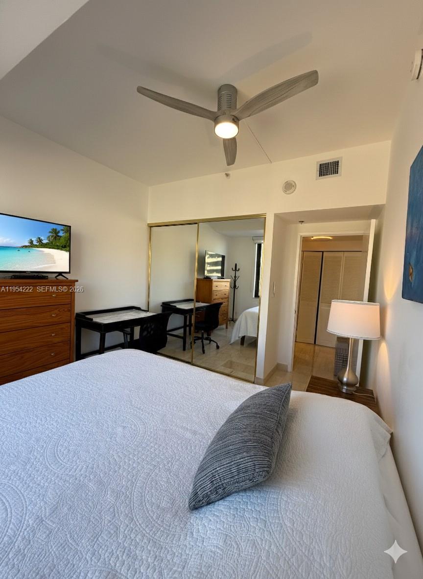 201 Crandon Boulevard, Unit 928 Key Biscayne, FL 33149 - Photo 18 of 38 a bedroom with a bed and lamp