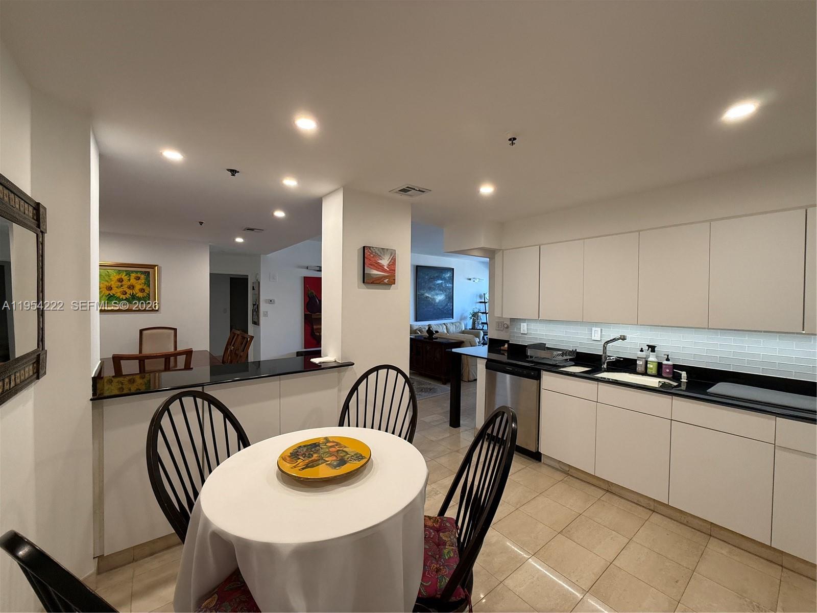 201 Crandon Boulevard, Unit 928 Key Biscayne, FL 33149 - Photo 22 of 38 a kitchen with stainless steel appliances granite countertop a stove a sink a dining table and chairs