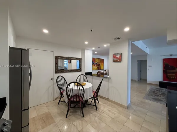 a view of a livingroom with furniture and a refrigerator