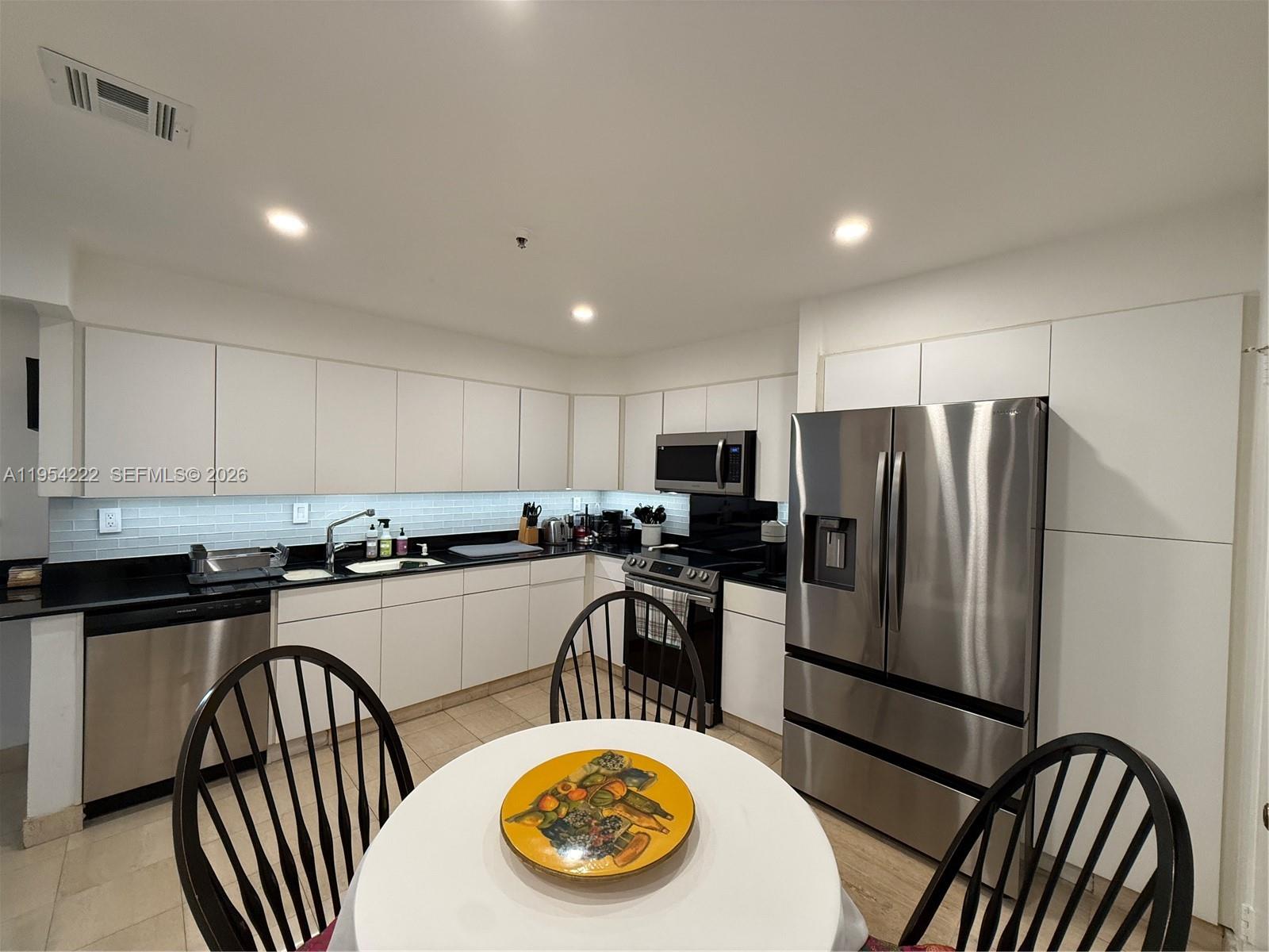 201 Crandon Boulevard, Unit 928 Key Biscayne, FL 33149 - Photo 24 of 38 a kitchen with refrigerator and stove