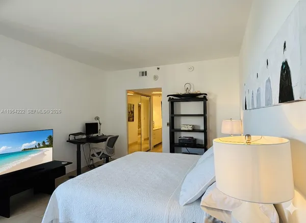 a bedroom with a bed and a television
