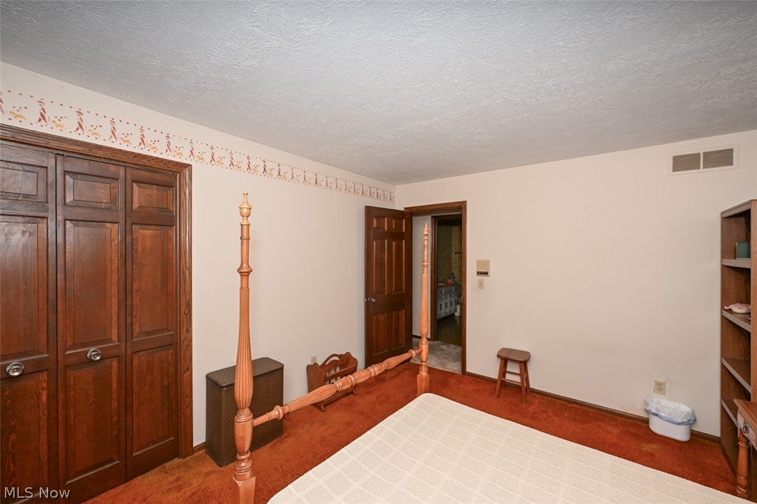 758 Inverness Road Akron, OH 44313 - Photo 33 of 46 Second bedroom featuring dark carpet, a closet, and a textured ceiling... again, notice the six panel wood doors