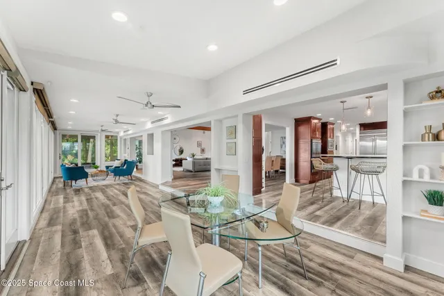a view of a dining room with furniture a kitchen and chandelier