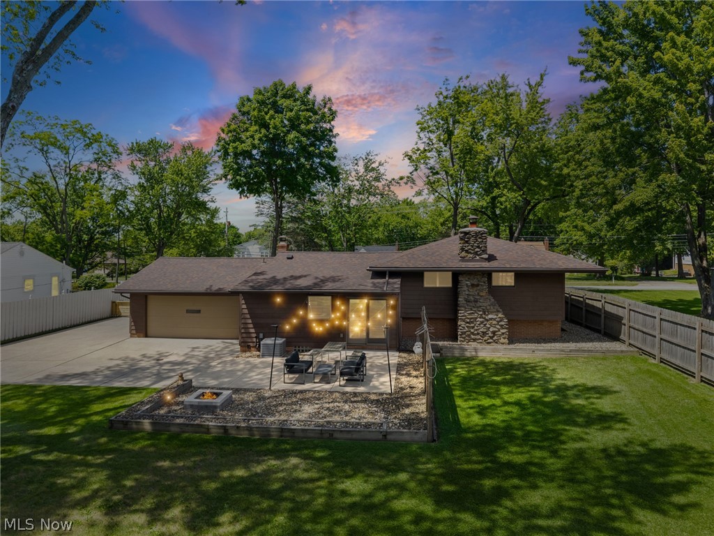 17583 Shurmer Road Strongsville, OH 44136 - Photo 46 of 50 Spacious backyard featuring a stone patio, built-in fire pit, and a grassy lawn