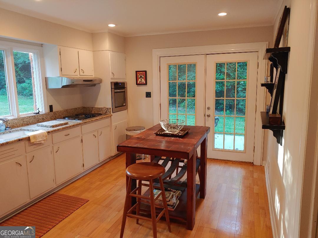 428 Wesleyan Drive Macon, GA 31210 - Photo 6 of 26 a kitchen with stainless steel appliances granite countertop a stove a refrigerator a sink a dining table and chairs with wooden floor