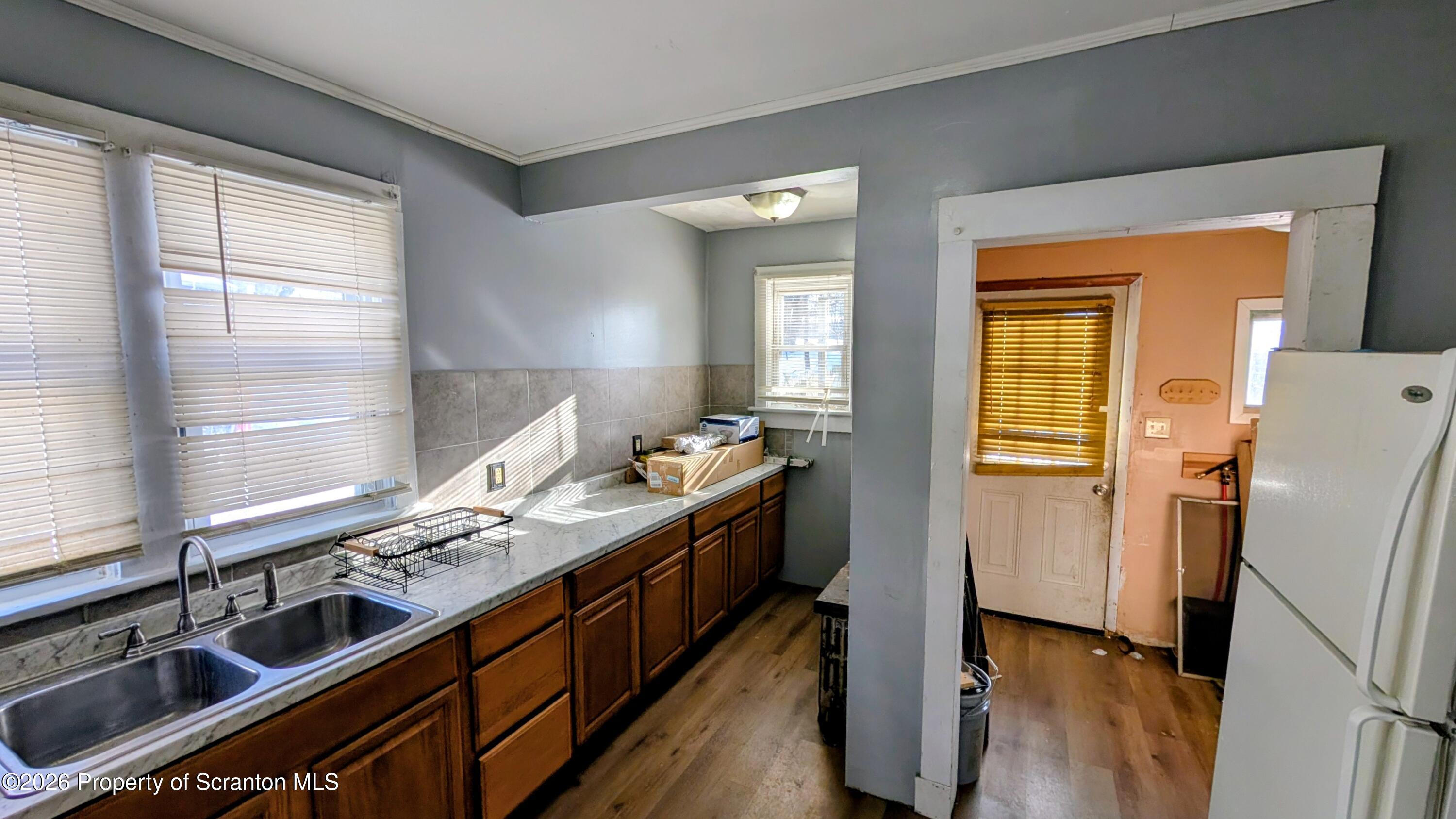509 Main Street Duryea, PA 18642 - Photo 13 of 30 a kitchen with stainless steel appliances granite countertop a refrigerator a sink dishwasher a stove and white countertops with wooden floor
