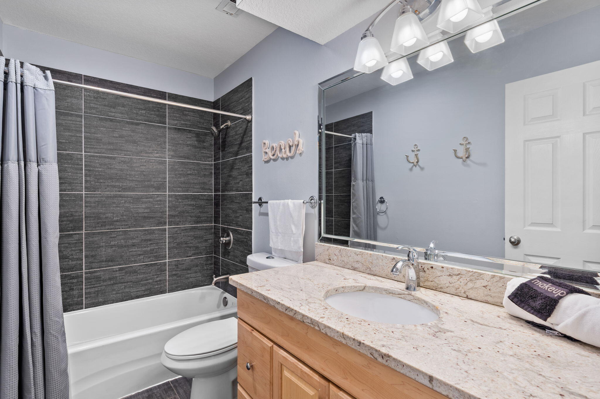 918 Harbour Point Lane, Unit 918 Miramar Beach, FL 32550 - Photo 14 of 43 a bathroom with a granite countertop sink a toilet a mirror a bathtub and shower