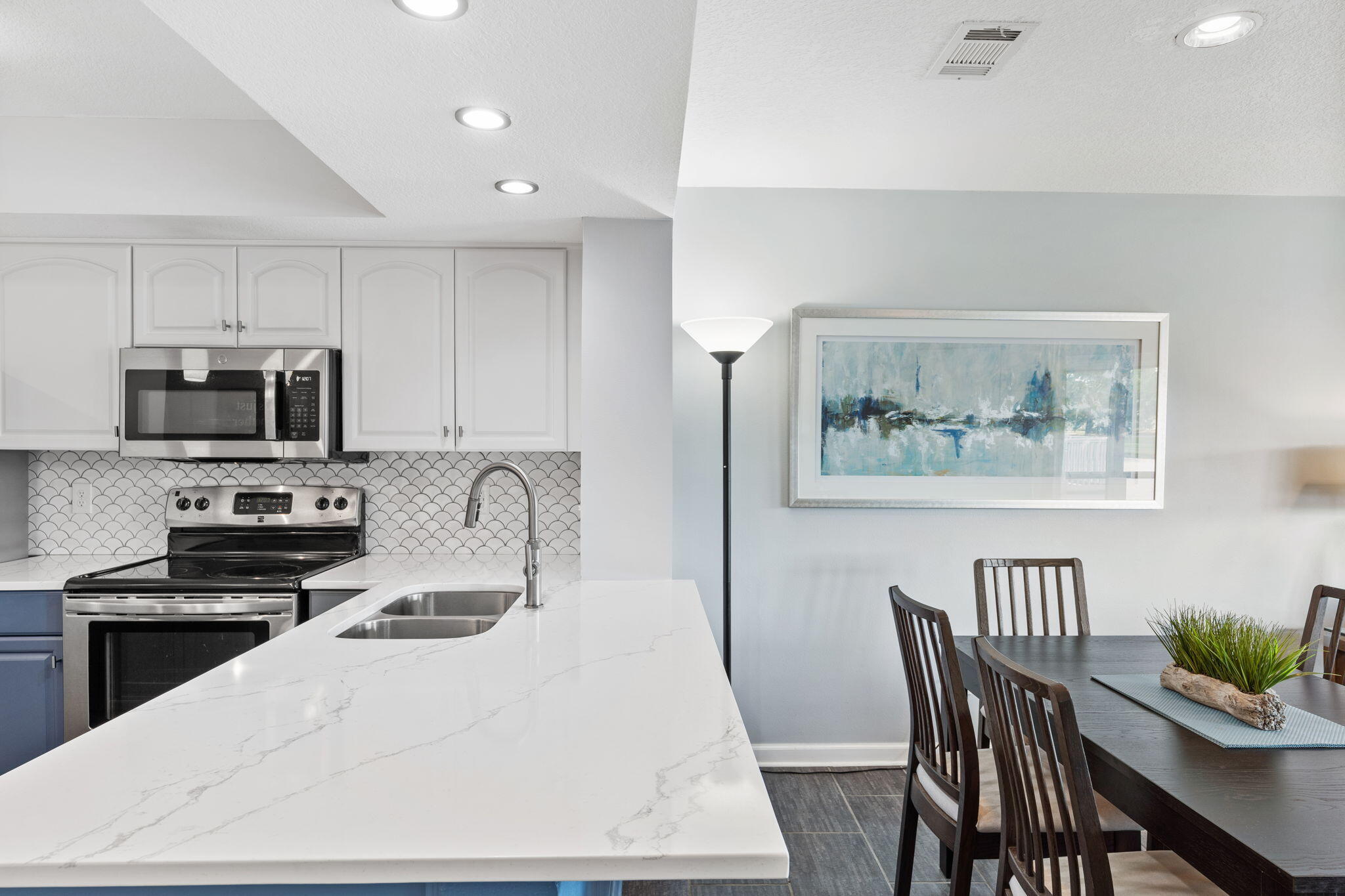 918 Harbour Point Lane, Unit 918 Miramar Beach, FL 32550 - Photo 26 of 43 a kitchen with stainless steel appliances a kitchen island a stove a table and chairs