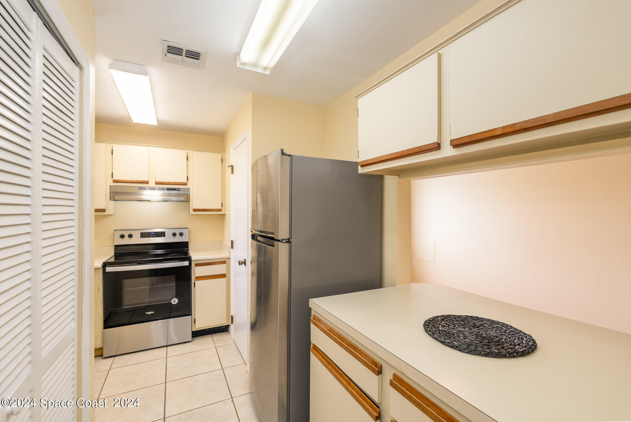280 Spring Drive, Unit 8 Merritt Island, FL 32953 - Photo 11 of 26 a kitchen with a refrigerator and a stove