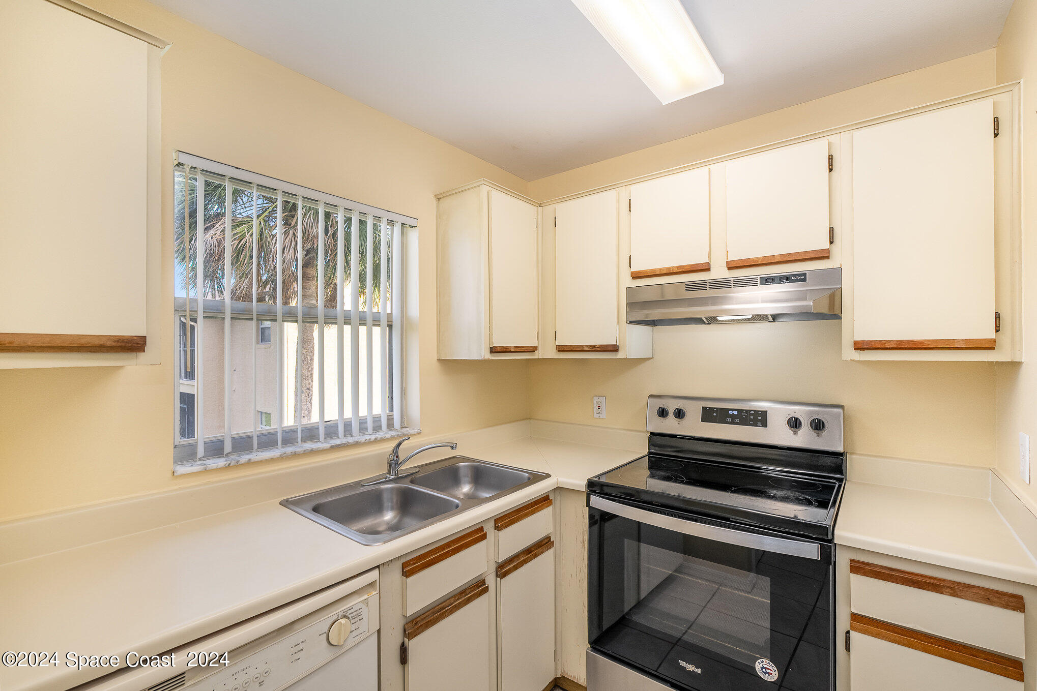 280 Spring Drive, Unit 8 Merritt Island, FL 32953 - Photo 12 of 26 a kitchen with a sink stove top oven and cabinets