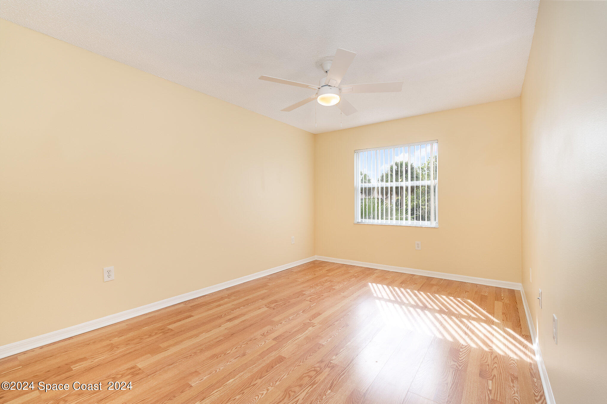 280 Spring Drive, Unit 8 Merritt Island, FL 32953 - Photo 17 of 26 an empty room with wooden floor fan and windows