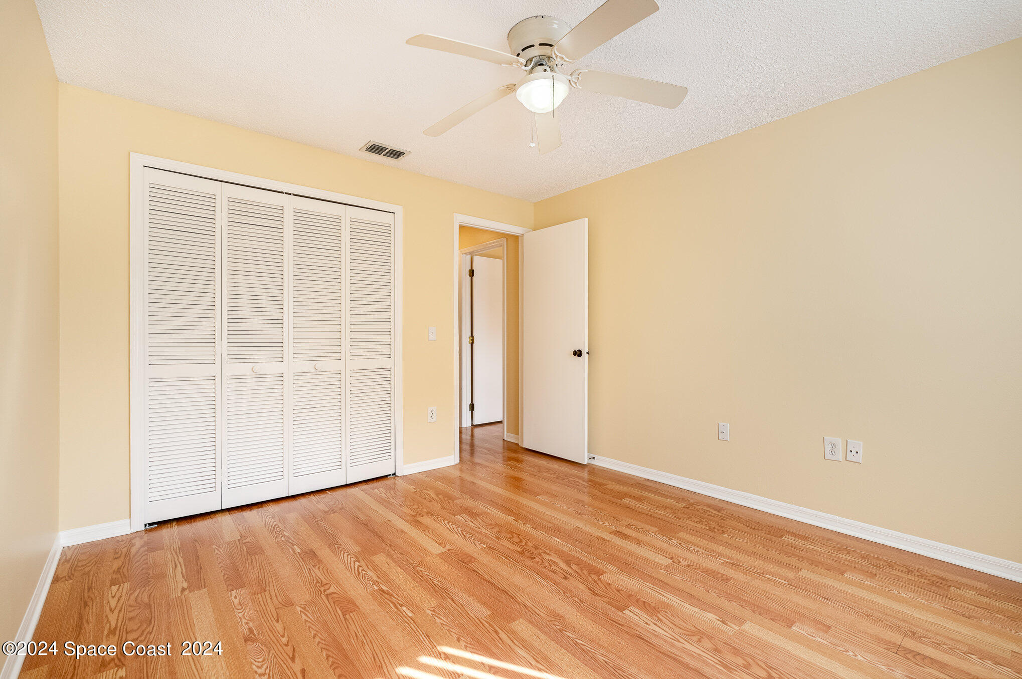 280 Spring Drive, Unit 8 Merritt Island, FL 32953 - Photo 18 of 26 an empty room with wooden floor closet and ceiling fan