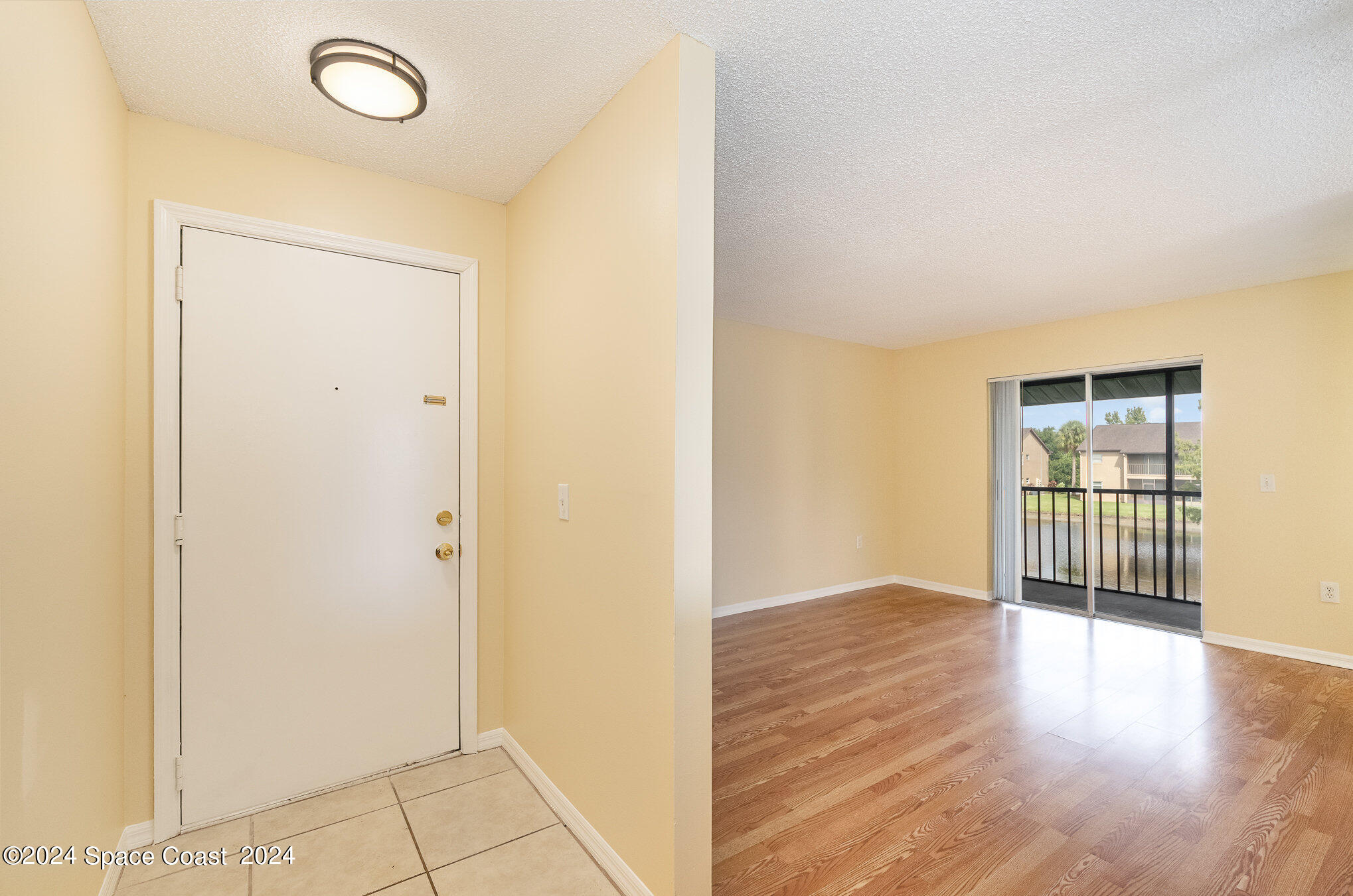 280 Spring Drive, Unit 8 Merritt Island, FL 32953 - Photo 4 of 26 a view of an empty room with wooden floor and a window