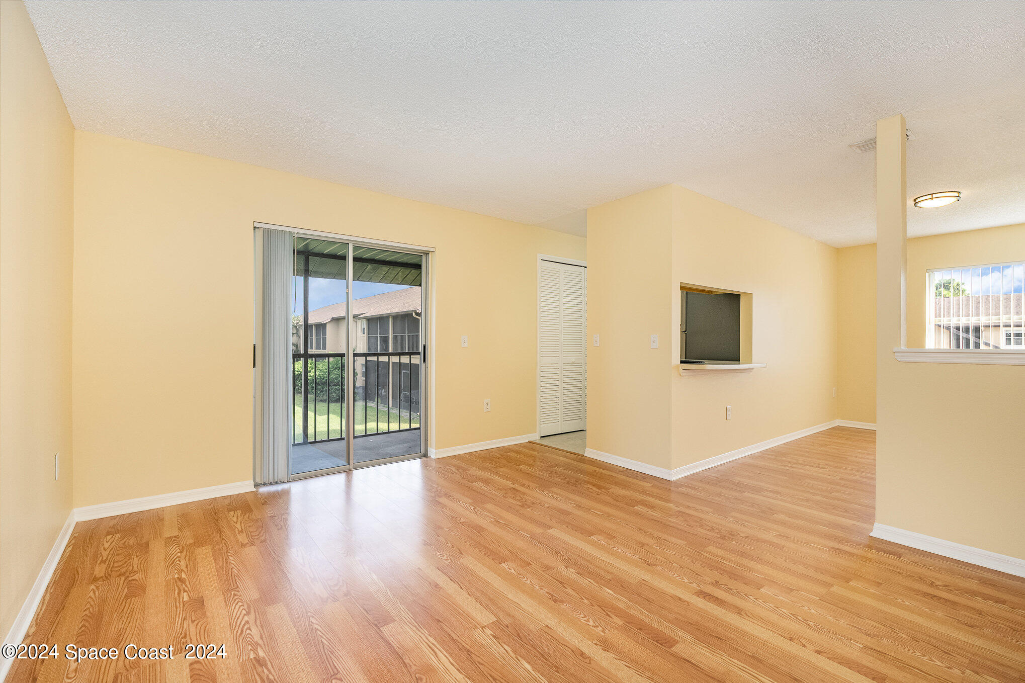 280 Spring Drive, Unit 8 Merritt Island, FL 32953 - Photo 6 of 26 a view of an empty room with wooden floor and a window
