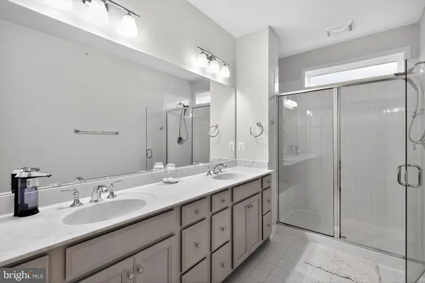 a bathroom with a double vanity sink mirror and shower