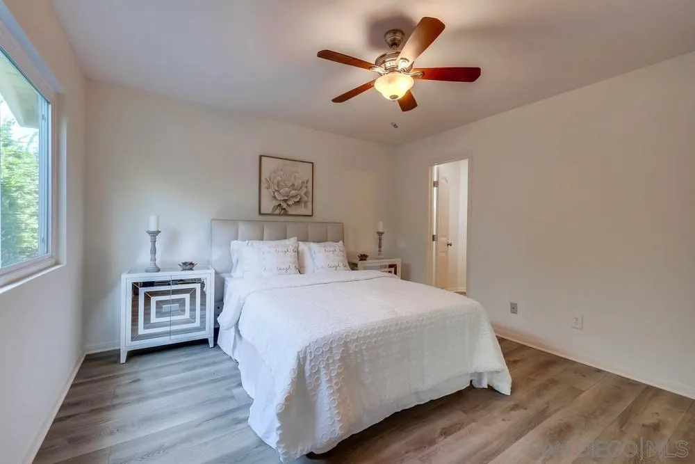 12711 Rios Road San Diego, CA 92128 - Photo 21 of 33 a bedroom with a large bed and a chandelier