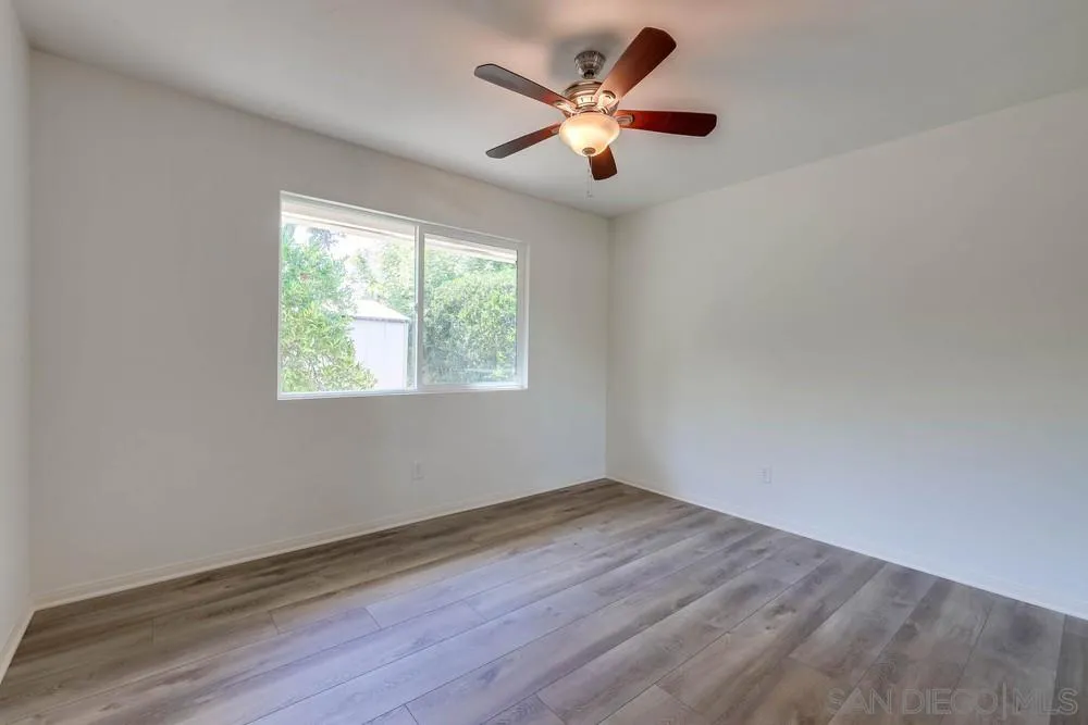 12711 Rios Road San Diego, CA 92128 - Photo 23 of 33 an empty room with wooden floor and windows