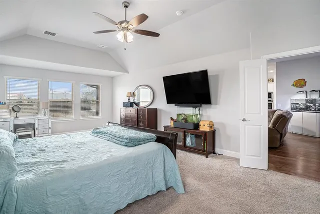 a spacious bedroom with a bed and a chandelier
