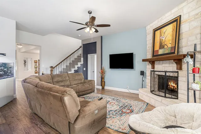 a living room with furniture a flat screen tv and a fireplace