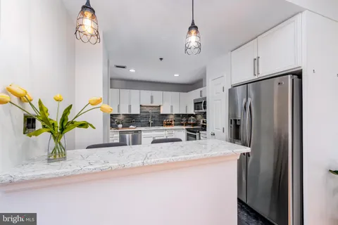 a kitchen with stainless steel appliances granite countertop a refrigerator a sink a stove and cabinets