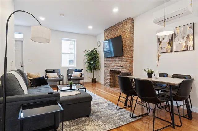 a living room with furniture a fireplace and a flat screen tv
