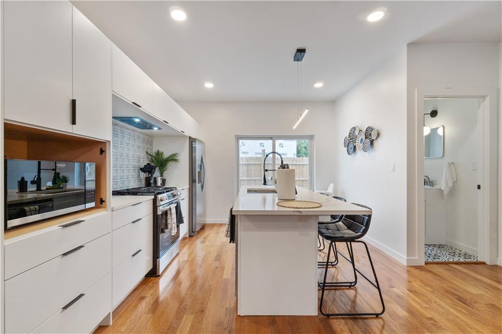 1240 Butterfield Way Pittsburgh, PA 15212 - Photo 8 of 35 a kitchen with stainless steel appliances kitchen island granite countertop a stove a sink and a refrigerator