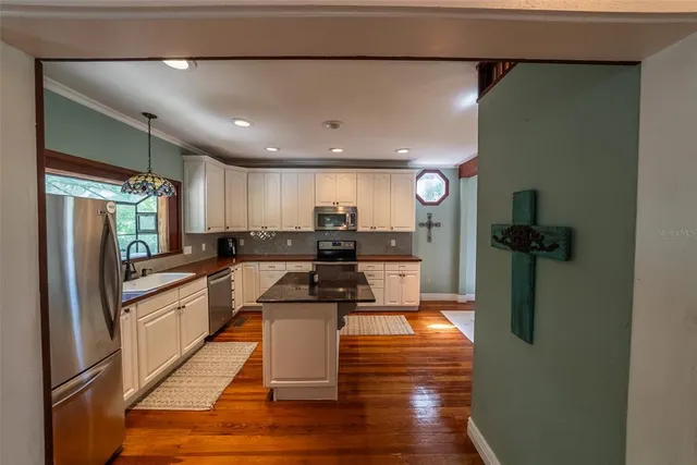 a kitchen with stainless steel appliances granite countertop a refrigerator stove microwave and sink