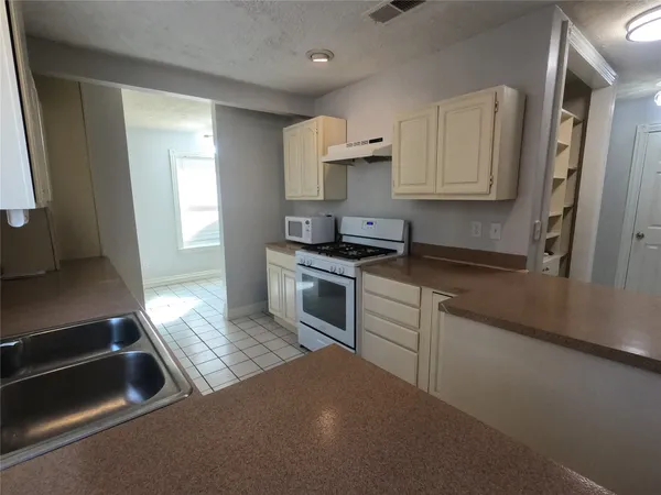 a kitchen with granite countertop a sink stainless steel appliances and cabinets