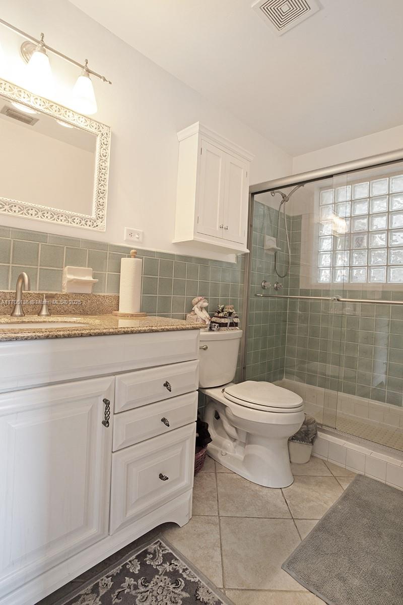 808 Mission Hill Road Boynton Beach, FL 33435 - Photo 36 of 68 a bathroom with a toilet a sink a shower and a mirror