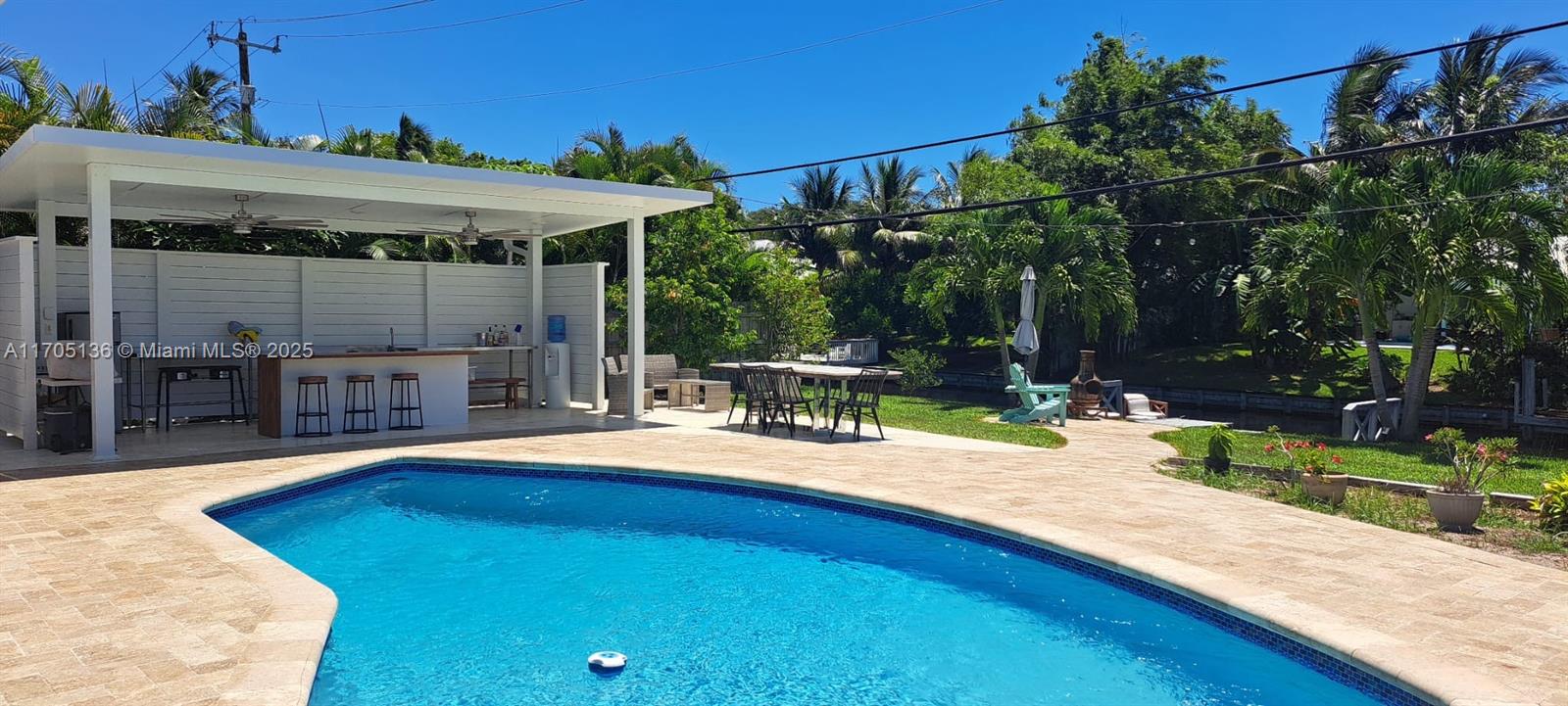 808 Mission Hill Road Boynton Beach, FL 33435 - Photo 67 of 68 a patio with table and chairs and potted plants