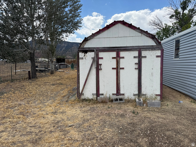 210 South State Street Moroni, UT 84646 - Photo 19 of 23 White storage shed with a gambrel roof and red trim