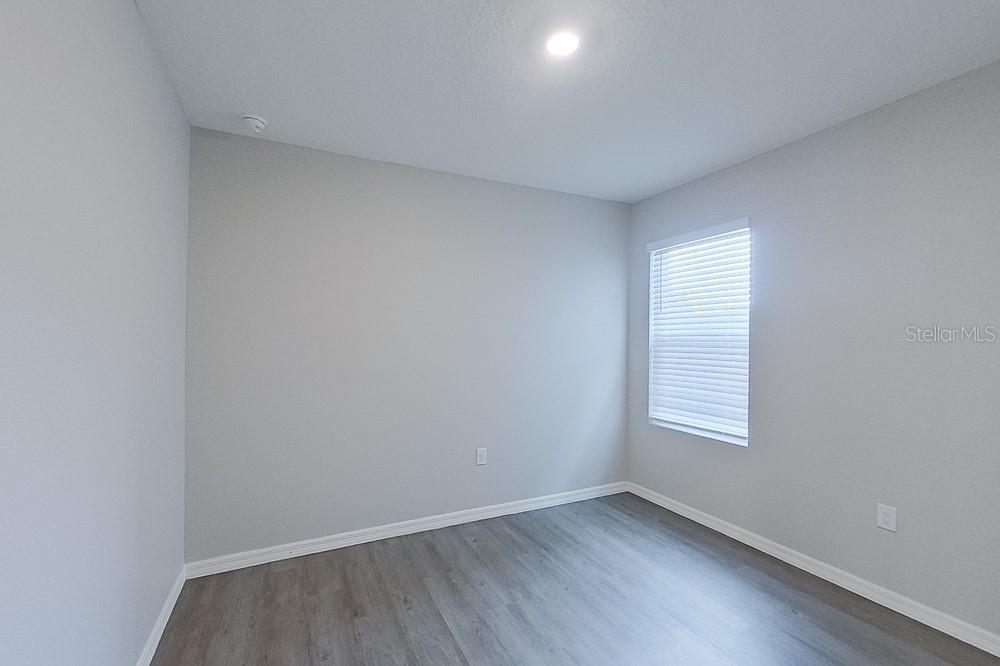 32044 Katelin Circle Leesburg, FL 34748 - Photo 11 of 20 an empty room with wooden floor and windows