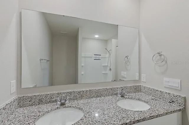 a bathroom with a granite countertop sink and a mirror