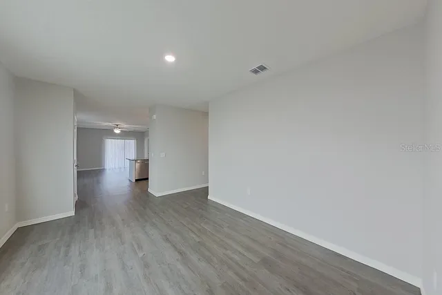 a view of a big room with wooden floor and windows