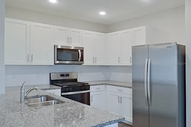 a kitchen with a refrigerator stove and microwave