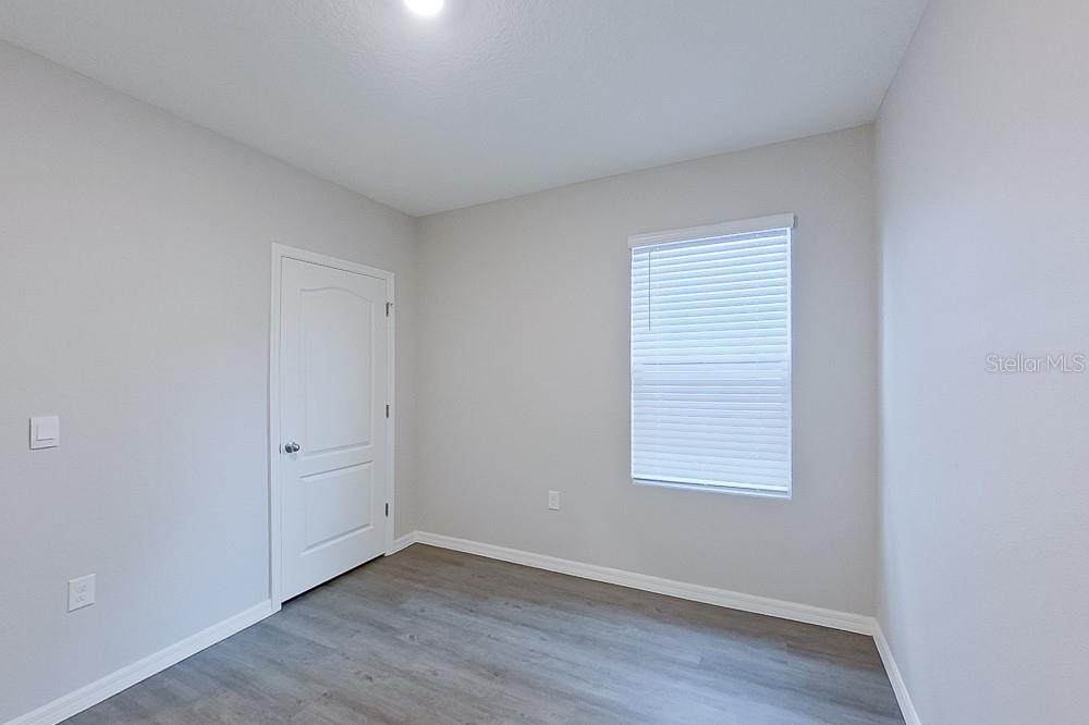 32044 Katelin Circle Leesburg, FL 34748 - Photo 10 of 20 an empty room with wooden floor and windows