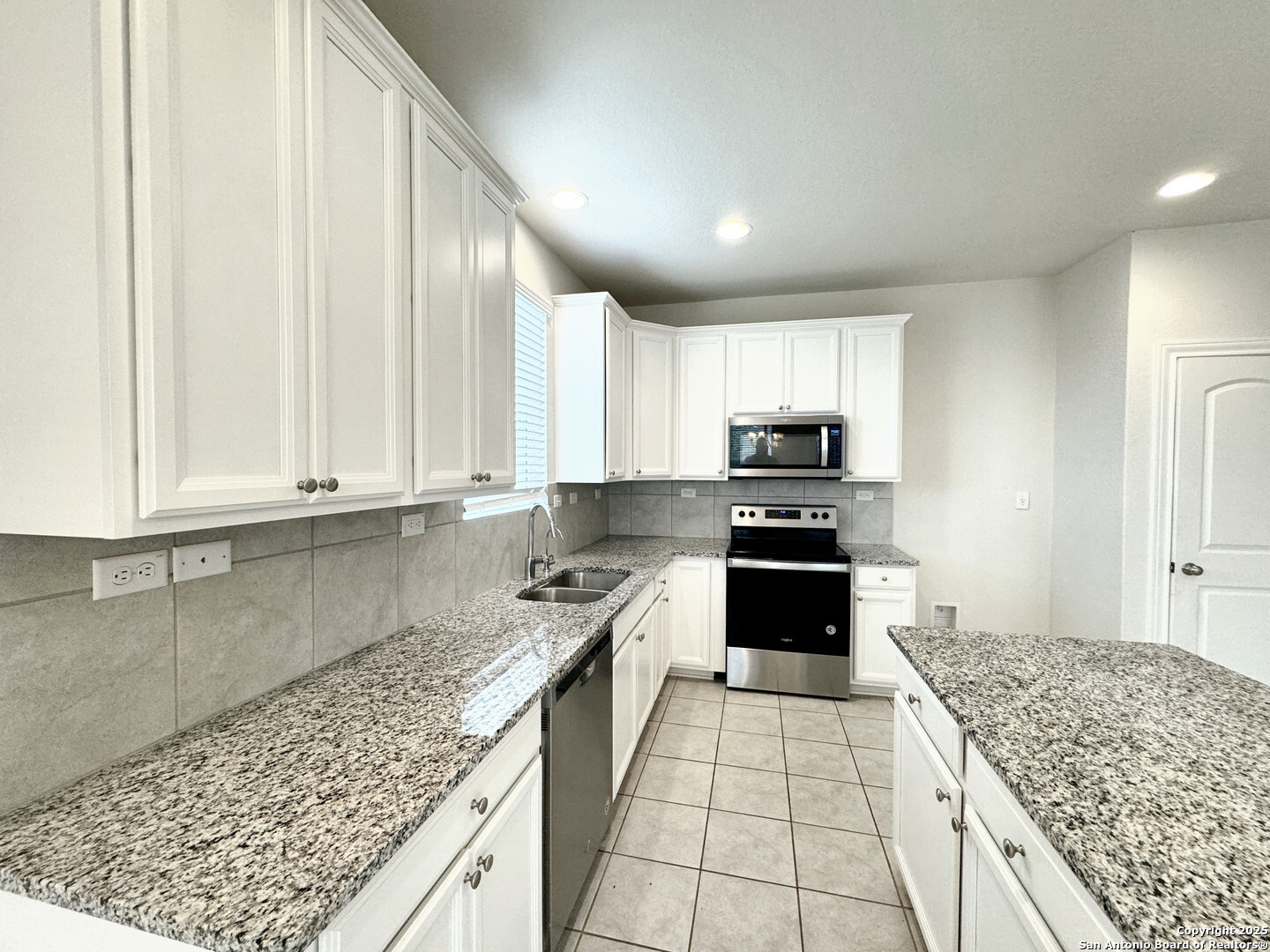 2858 Ridge Berry Road New Braunfels, TX 78130 - Photo 14 of 19 a kitchen with granite countertop a stove sink and cabinets