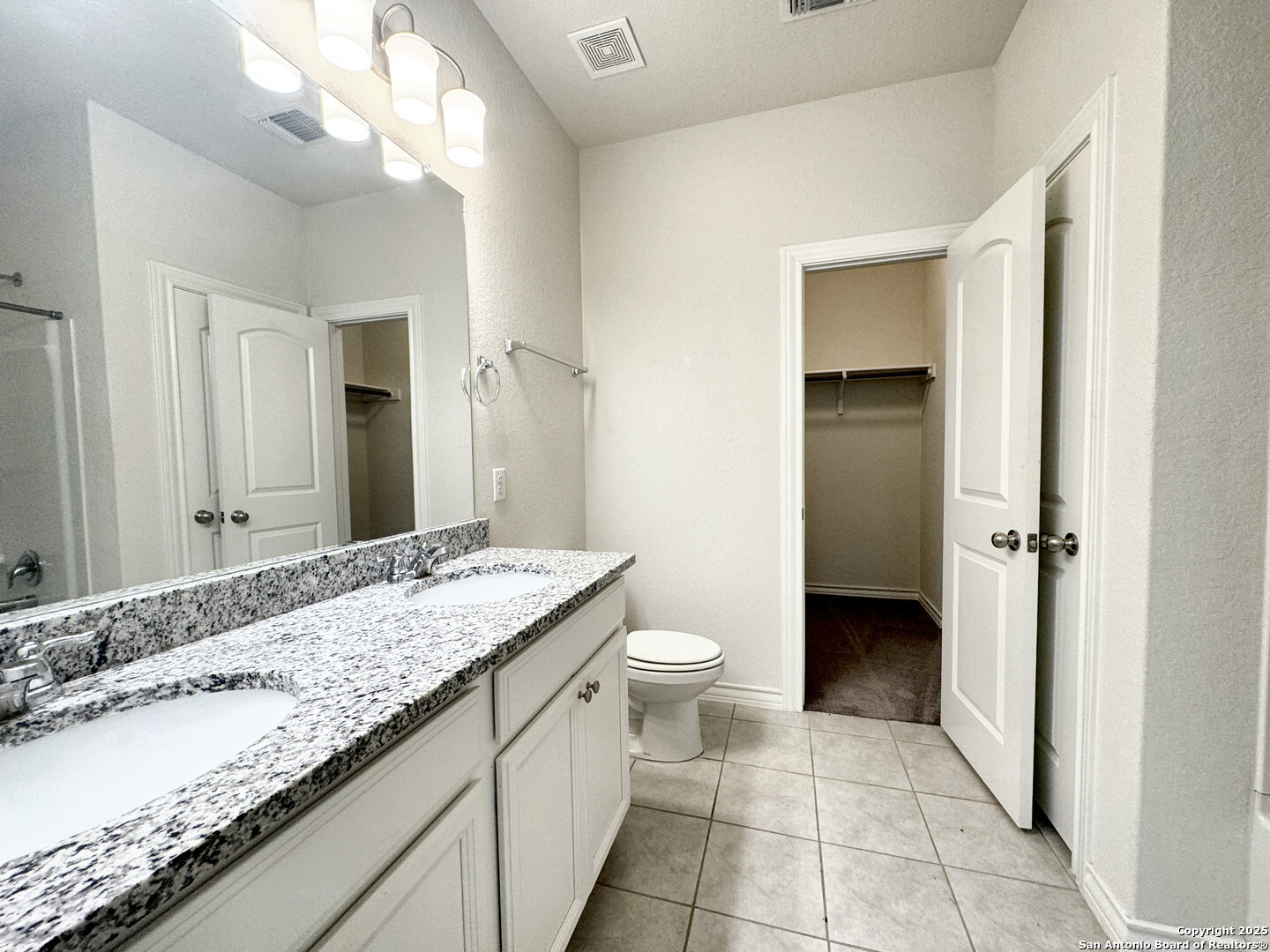 2858 Ridge Berry Road New Braunfels, TX 78130 - Photo 7 of 19 a bathroom with a granite countertop sink a toilet and a mirror