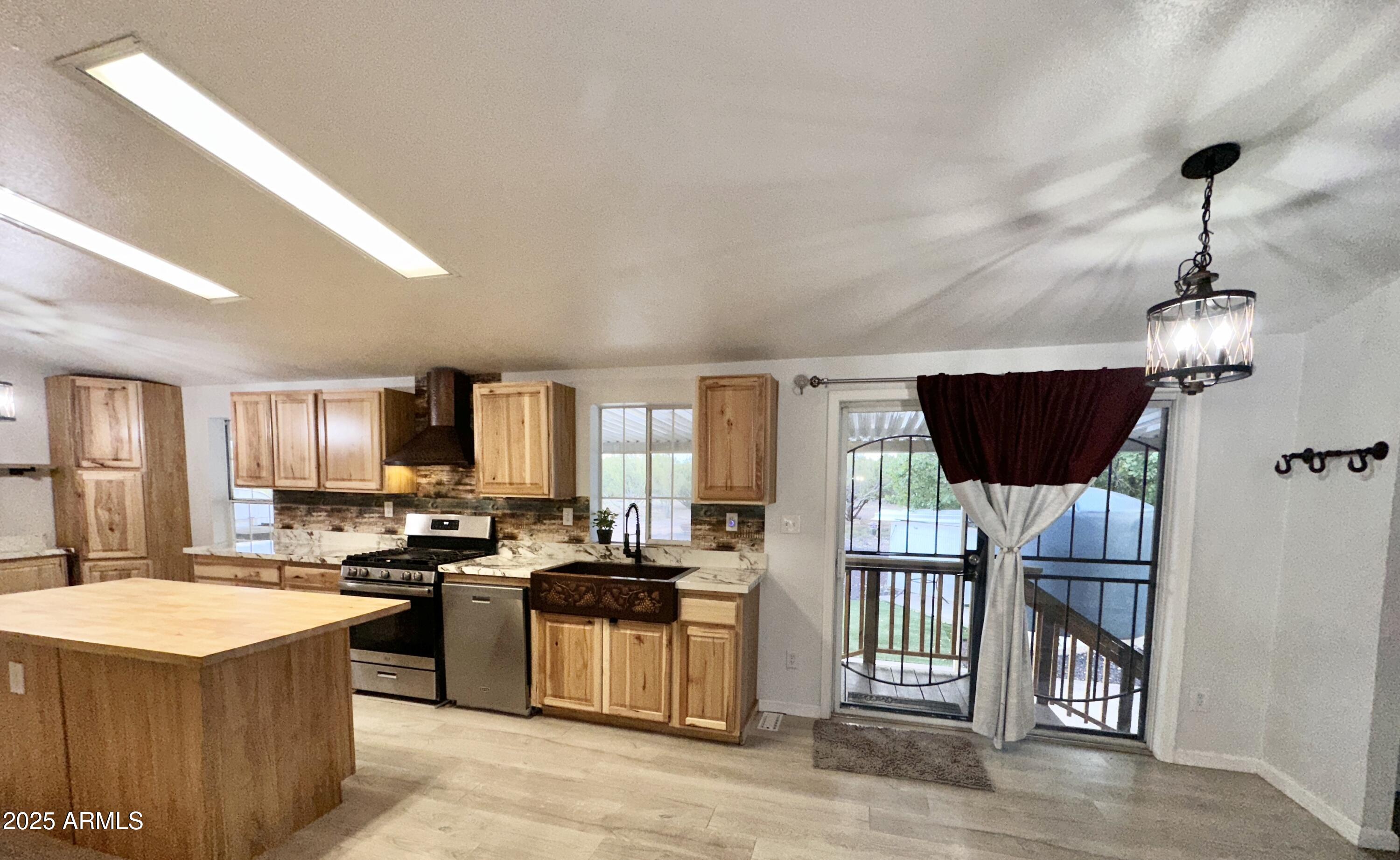 80 Acr 8050 Road Concho, AZ 85924 - Photo 10 of 30 a kitchen with stainless steel appliances granite countertop a stove top oven a refrigerator a sink dishwasher and a dining table with wooden floor