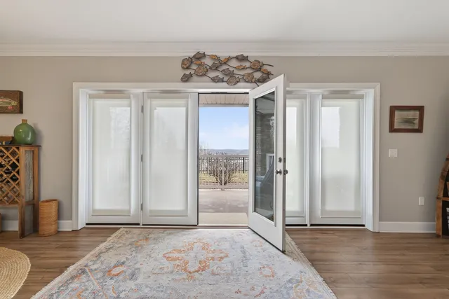 an empty room with wooden floor and a rug