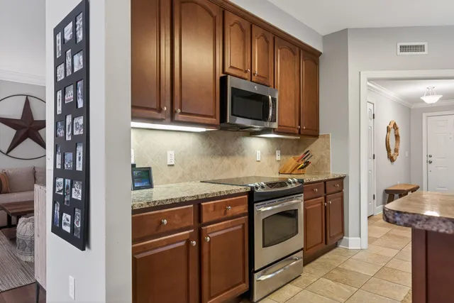a kitchen with stainless steel appliances granite countertop a stove and a microwave