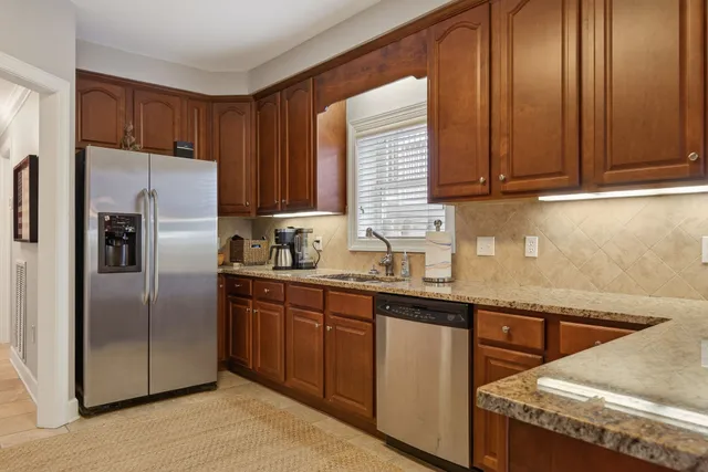 a kitchen with stainless steel appliances granite countertop a refrigerator a sink and dishwasher