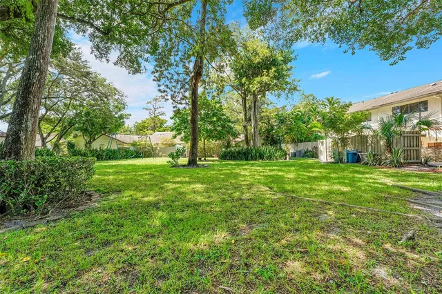 a view of green field with trees in the background