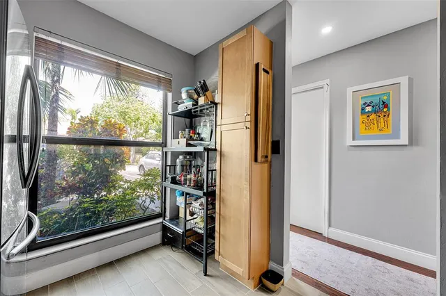 a view of a hallway with wooden floor and a bathroom