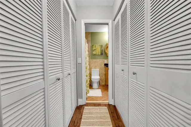 a bathroom with a granite countertop sink a toilet and shower curtain