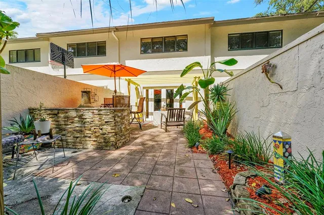 a view of a patio with table and chairs potted plants