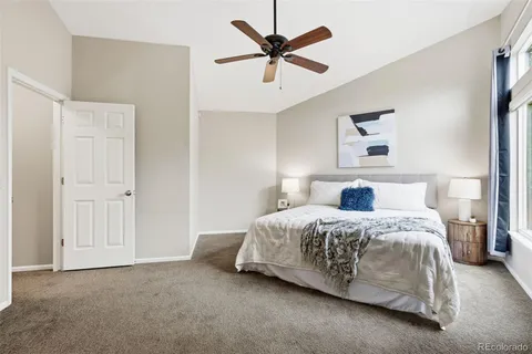 a spacious bedroom with a bed and a ceiling fan